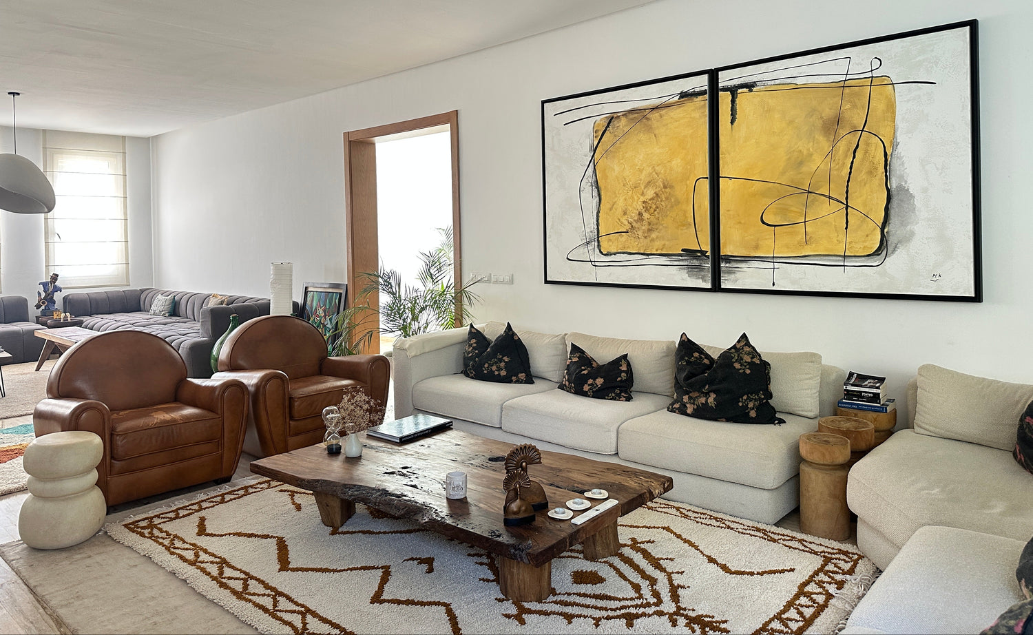 Modern living room with abstract art, comfortable furniture, and a coffee table.