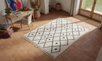 BENI OUARAIN rug with pillows and a small table on grass
